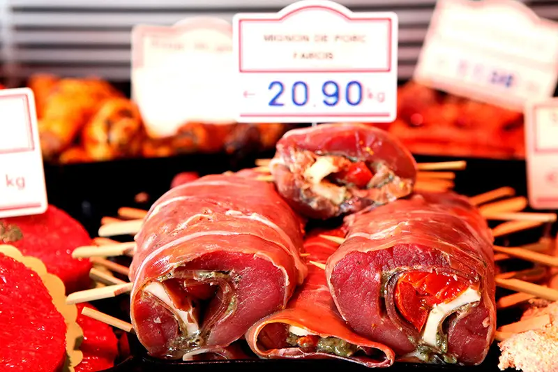 Pièces de viande rouge en vitrine, étiquetées à la main